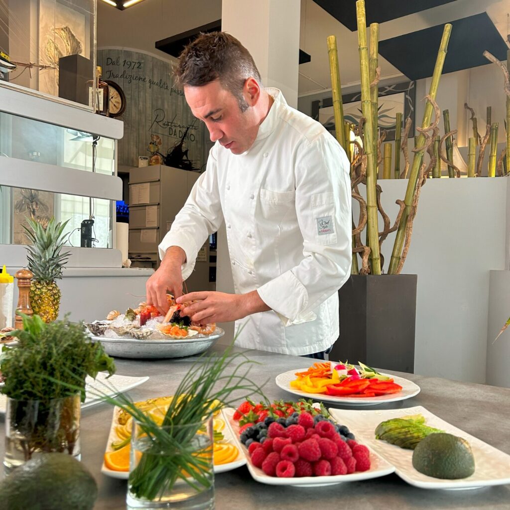 chef all'opera con piatti di mare e frutta - ristorante per eventi